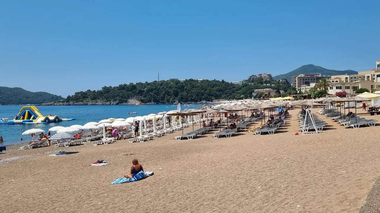 Swimmers and an inflatable aqua-park in the turquoise water just off Bečići Beach