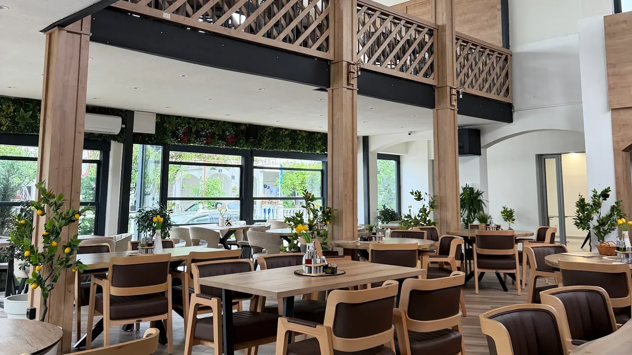 A bright, welcoming café and restaurant interior with wooden tables and warm lighting