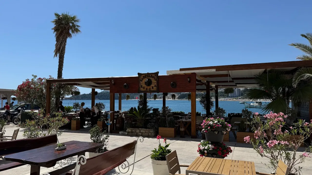 A quiet seafront restaurant terrace shaded by a pergola on the Budva Riviera