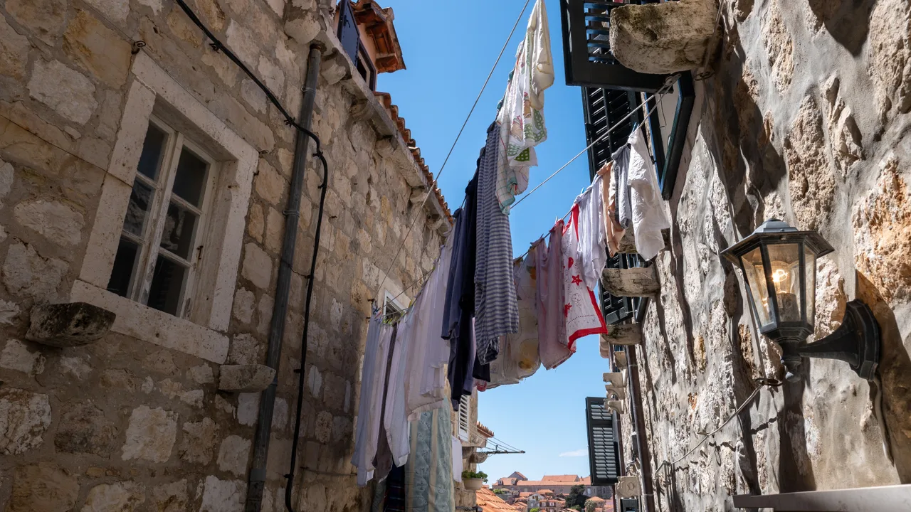 A walled Adriatic old town rising above the sea on a rocky headland