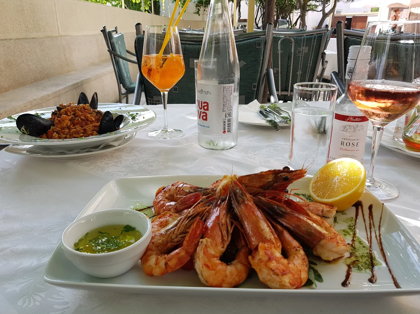 Grilled prawns and seafood risotto on a garden-terrace table at Restaurant Atlantic in Rafailovići