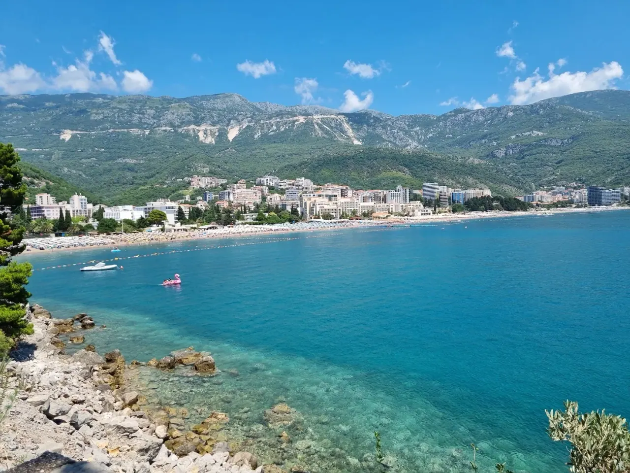The long sandy sweep of Bečići Beach with resort hotels and the coastal mountains behind