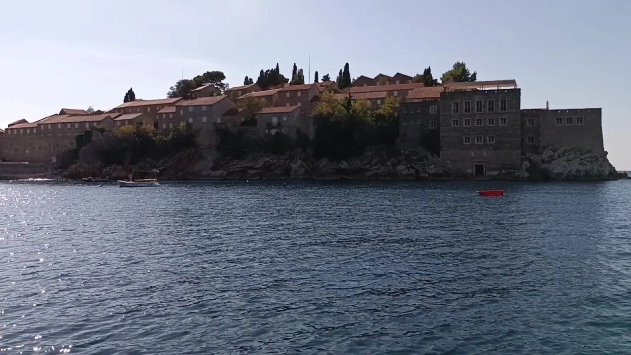 The fortified islet of Sveti Stefan seen from the sea, its stone houses and red roofs