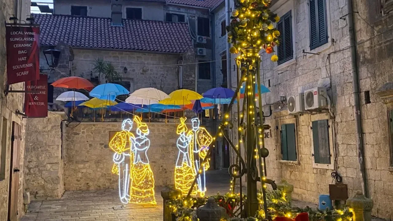 A lantern-lit stone lane in Kotor's medieval old town at dusk