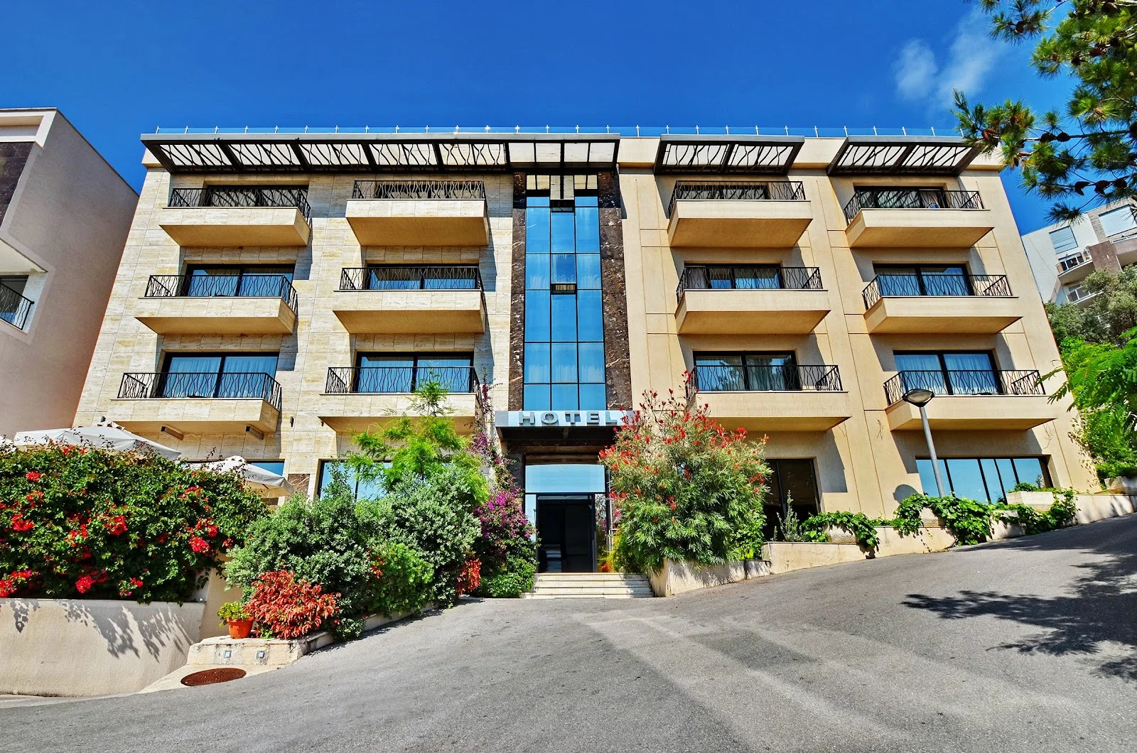 The stone-and-glass facade of Hotel HEC Residence near Miločer