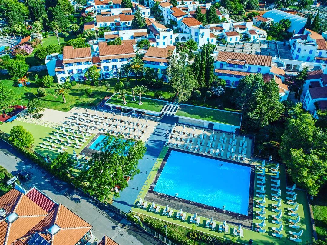 Aerial view of Hotel Aleksandar's low-rise resort buildings and big outdoor pools in Budva