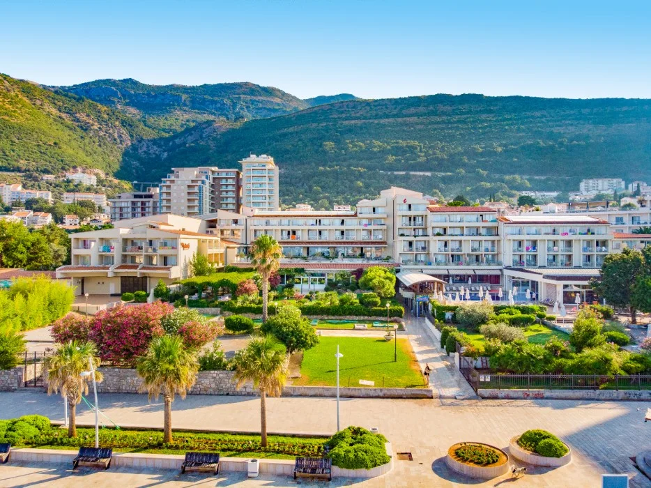 Aerial view of Hotel Palas and its terraced seafront gardens against the mountains at Petrovac