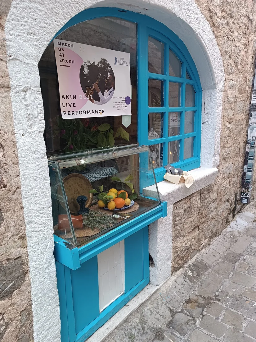 Blue-framed stone window with a citrus and herb display at Konoba Stari Grad inside Budva's Old Town