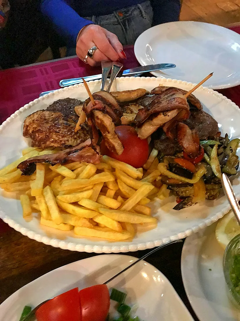 A large seafood platter of lobster, langoustines, prawns and octopus on a wooden board at Restaurant Porto by the Budva marina