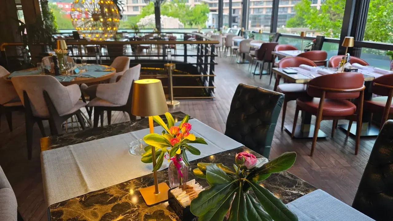 Leafy terrace dining room with warm lighting at Perla Restaurant & Club in Bečići